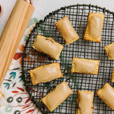Homemade Pop Tarts with a brown sugar glaze on a black wire rack.