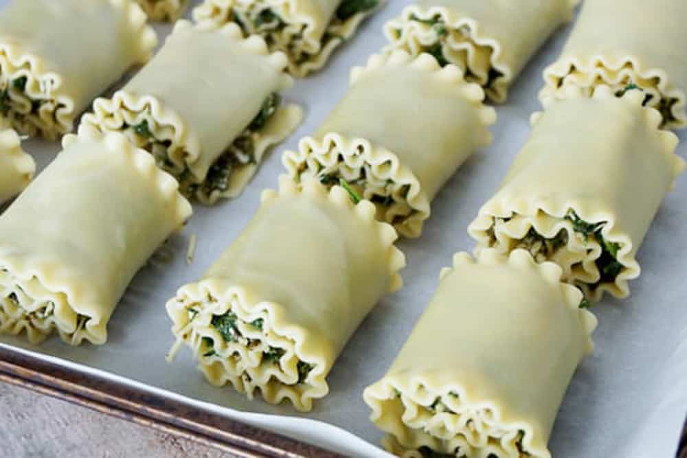 lasagna roll ups with spinach inside of them. 