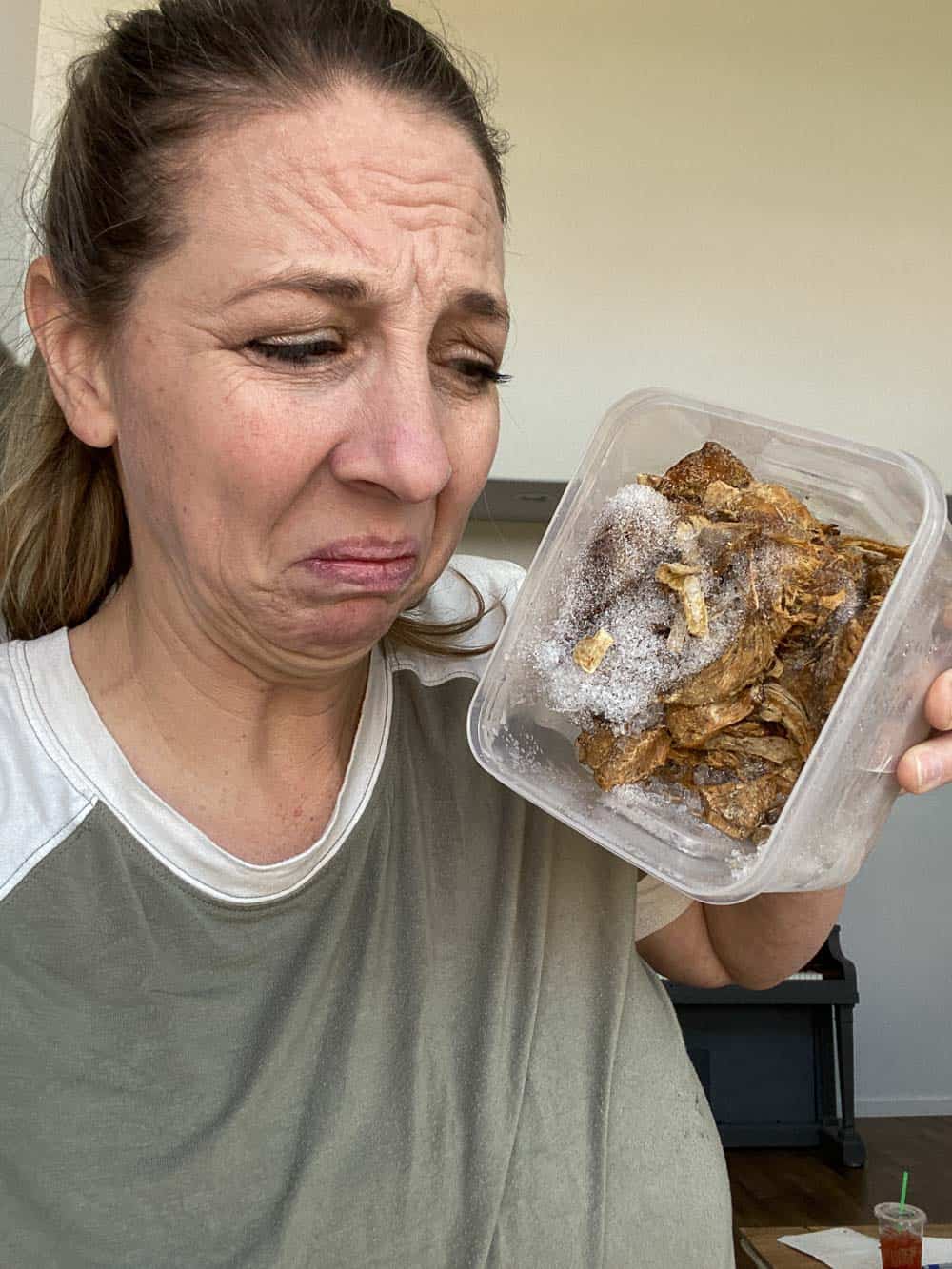 Woman holding a bowl with roast beef that is freezer burnt and has ice crystals