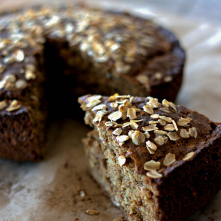 Slice of brown bread being removed from a round loaf.