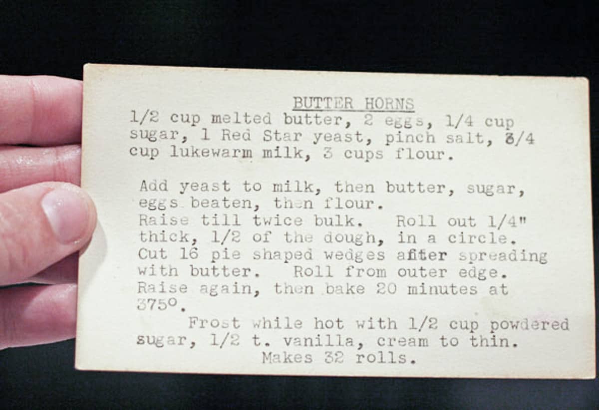 Old fashioned typed recipe card with a hand holding it on the left side.