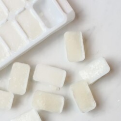Cubes of frozen milk next to an ice cube tray.