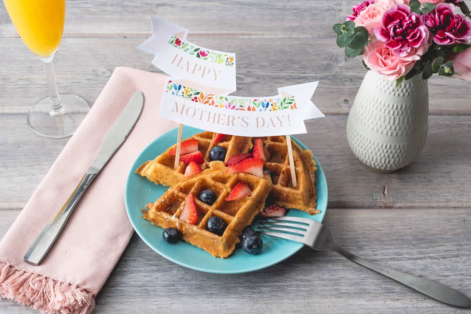 17 Frugal and Free Mother's Day Gift Ideas - Happy Mother's Day free printable banner on breakfast in bed blue plate with waffle and fresh fruit. 