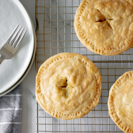 Mini chicken pot pies on a wire rack.