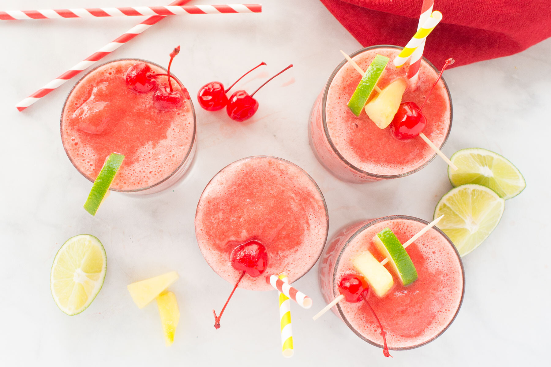 These kid friendly freezer meals are perfect with these 4 glasses of slush with cherries, limes and striped straws.