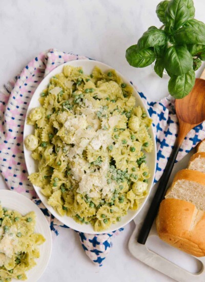 White oval dish of pesto past salad.