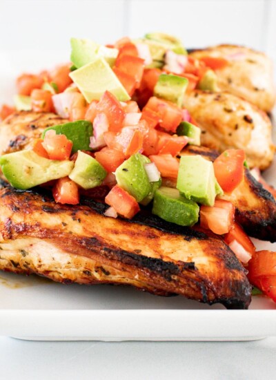 Serving plate of lime cilantro chicken with avocado salsa.