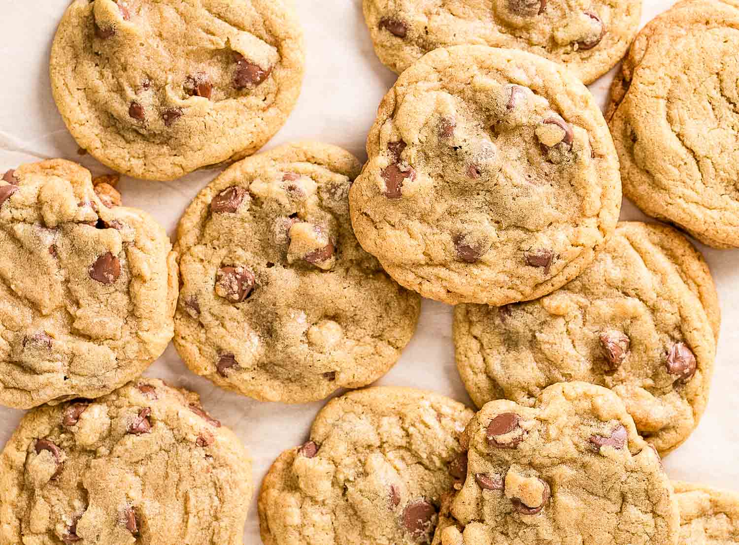 Chocolate chip cookies laying on a counter.