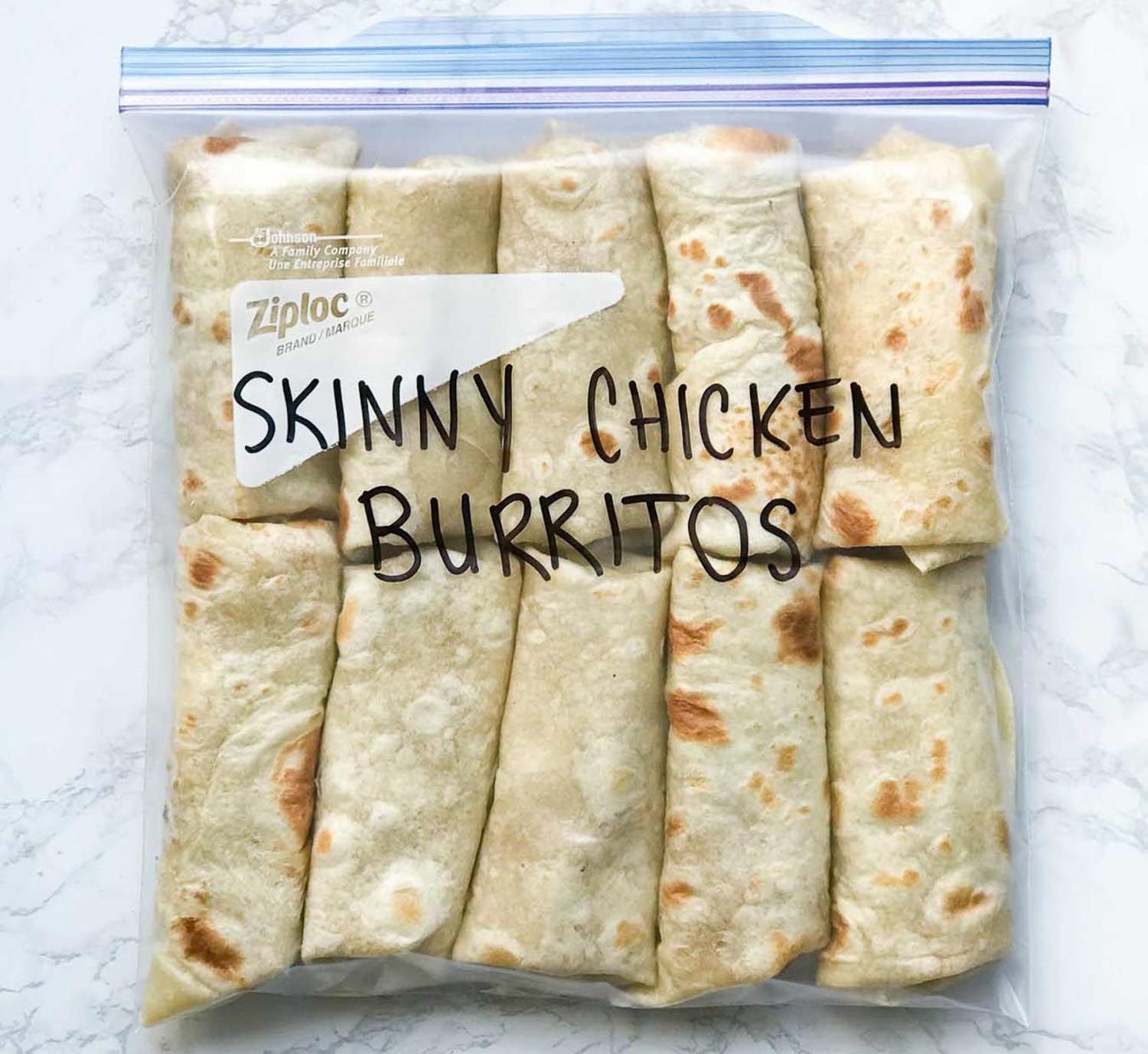A gallon size ziploc bag filled with 5 burritos and the words "Skinny Chicken Burritos" on it.