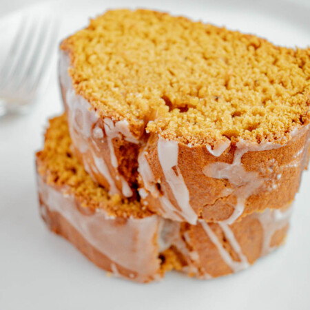 Two stacked slices of cinnamon glazed pumpkin spice bread.