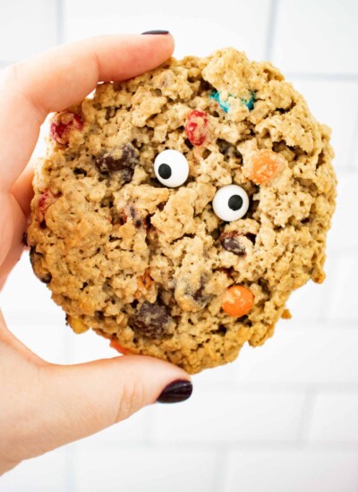 Person holding a cookie with candy eyeballs.