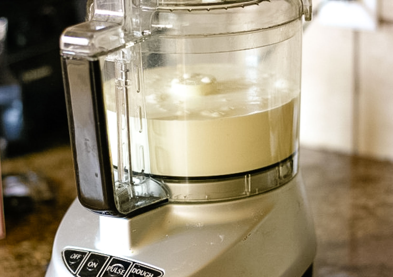 A food processor with cream in it.