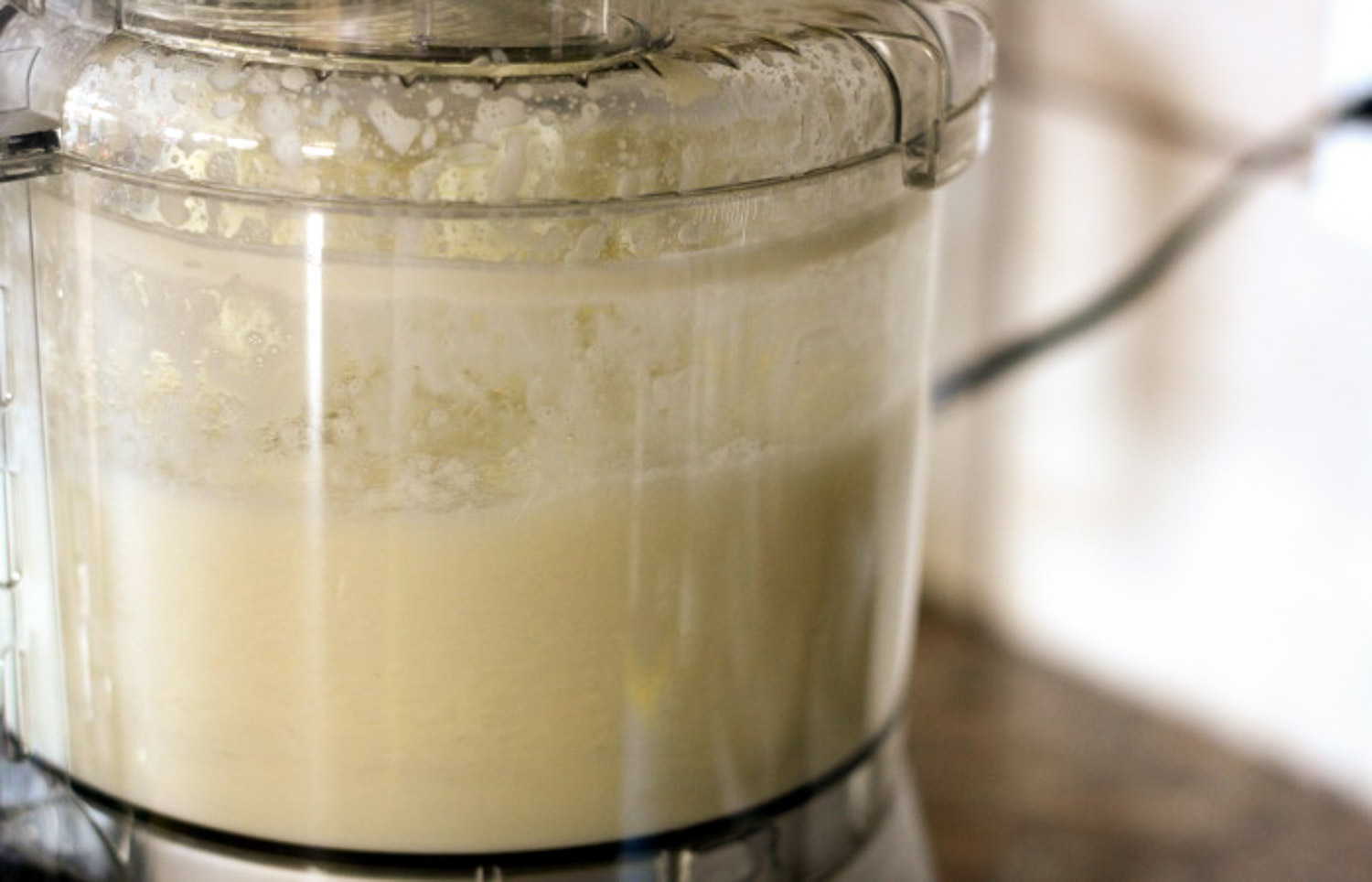 A food processor with cream in it after it has been run.