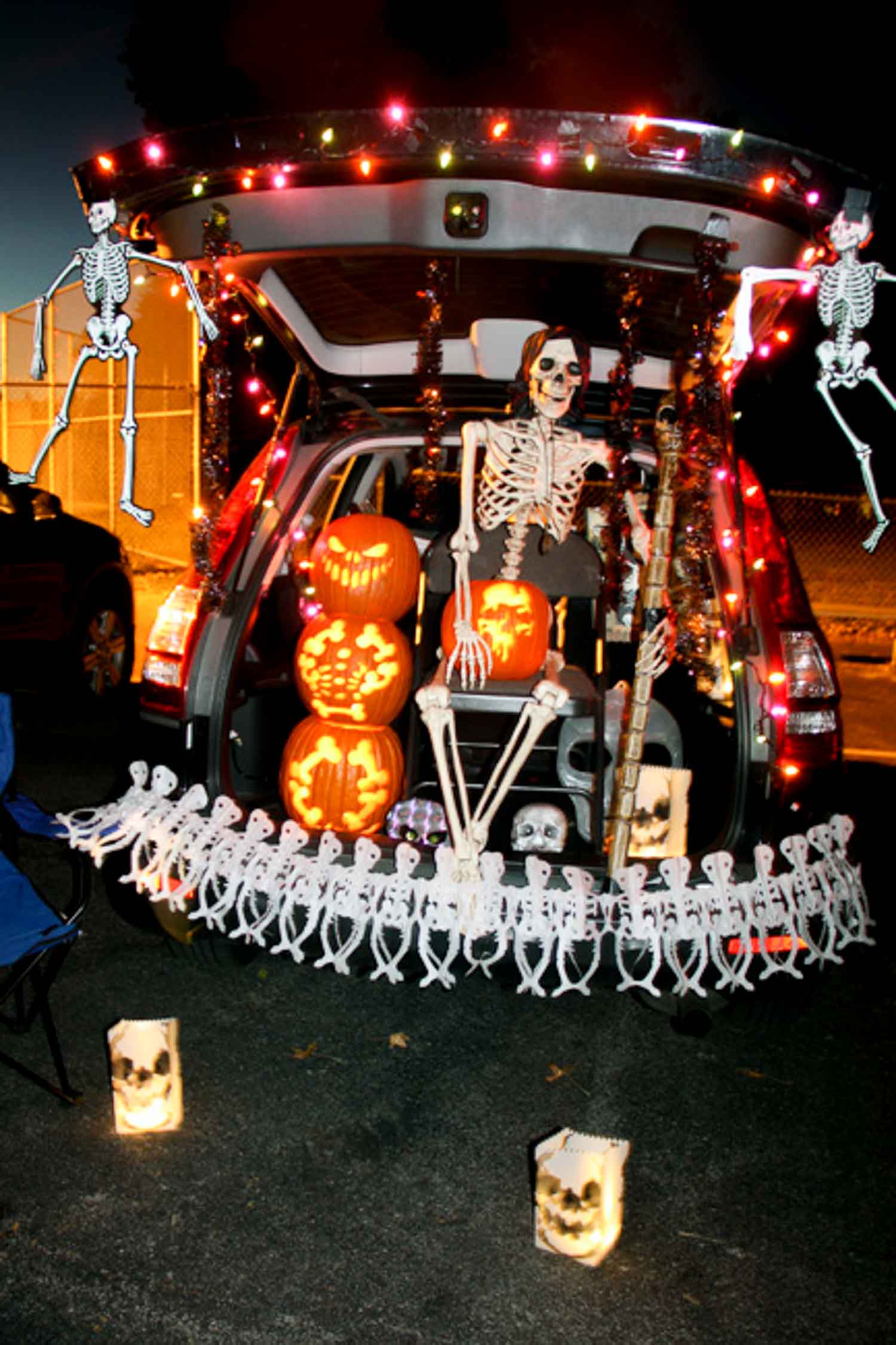 A trunk decorated with skeletons, pumpkins and lights for a spooky Halloween night.