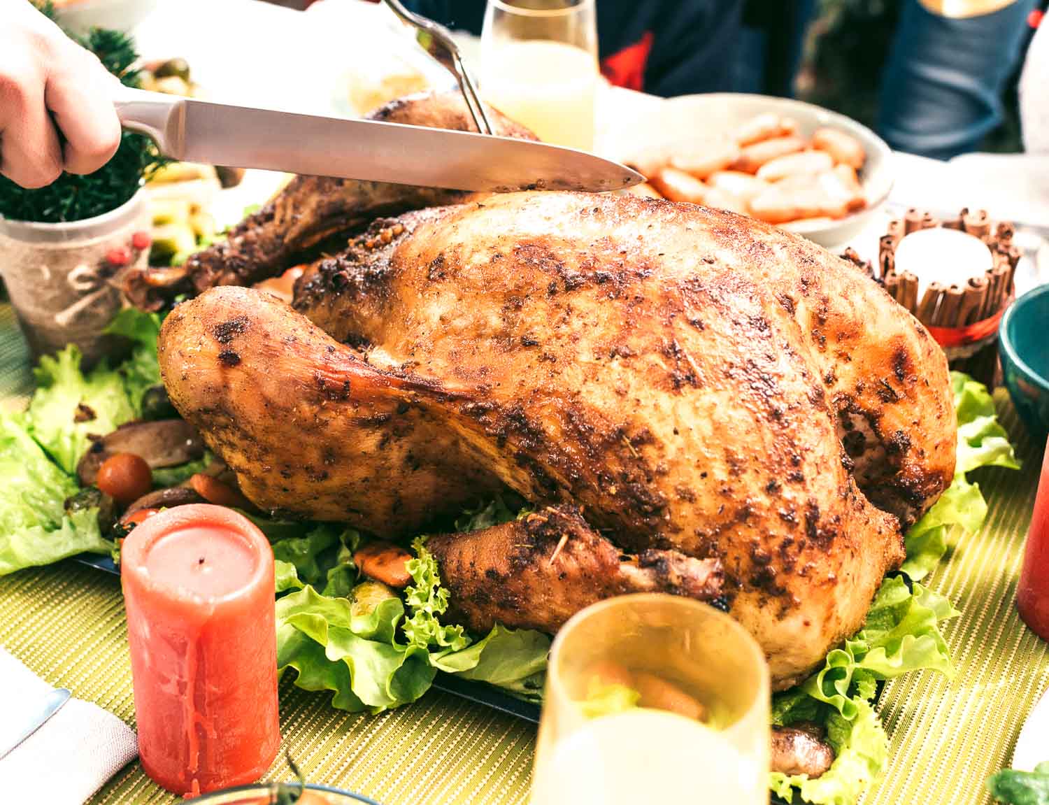 A white platter with a whole cooked, seasoned turkey.