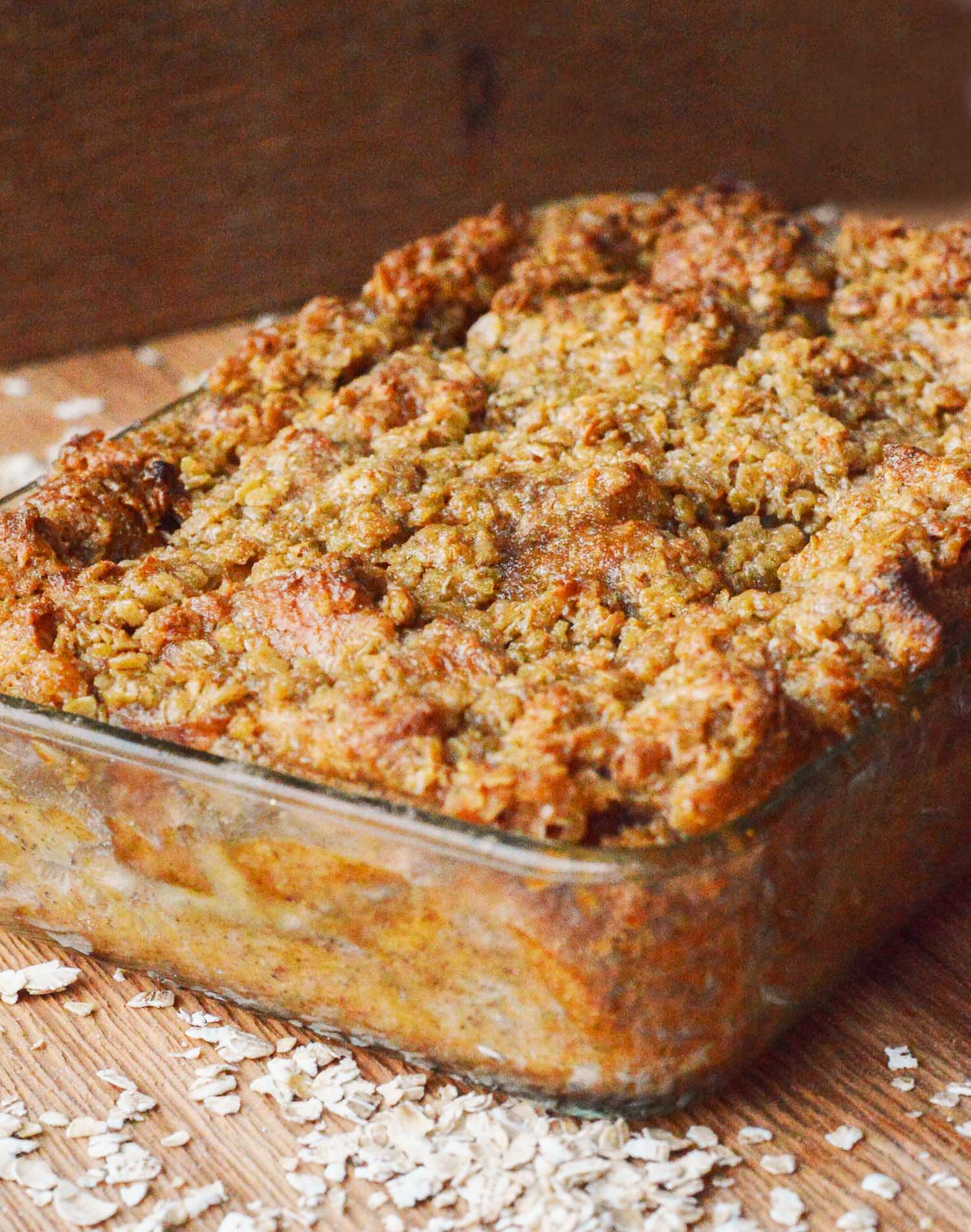 A glass pan of French toast casserole with some oatmeal scattered around it.