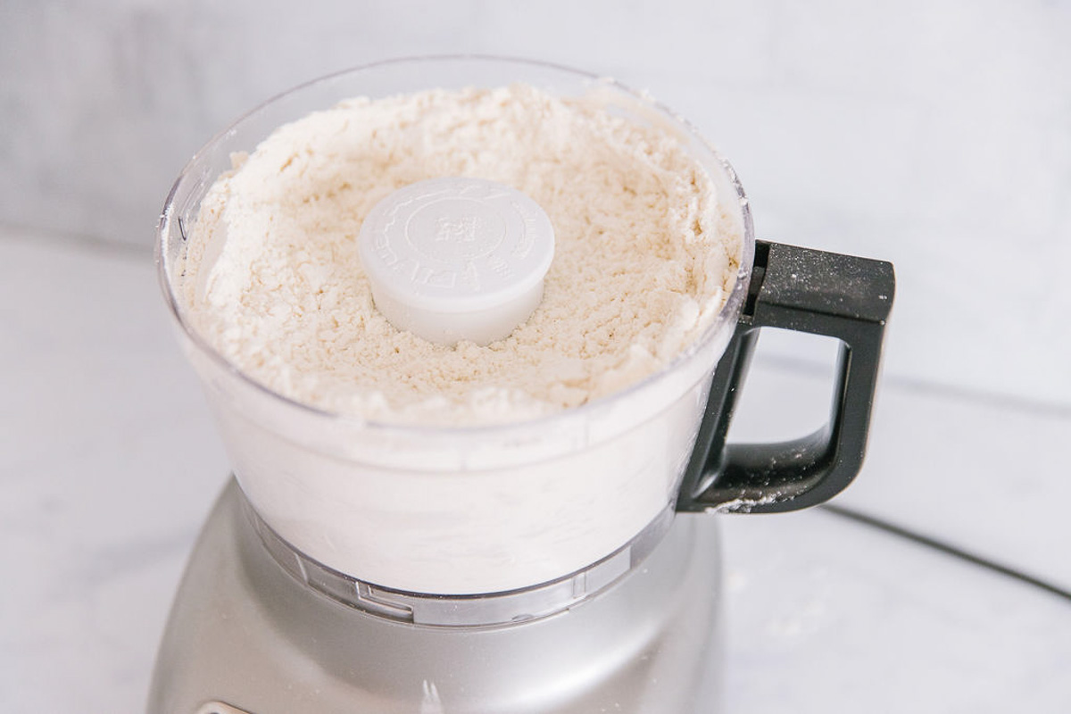 A food processor with a dry bisquick mix in it