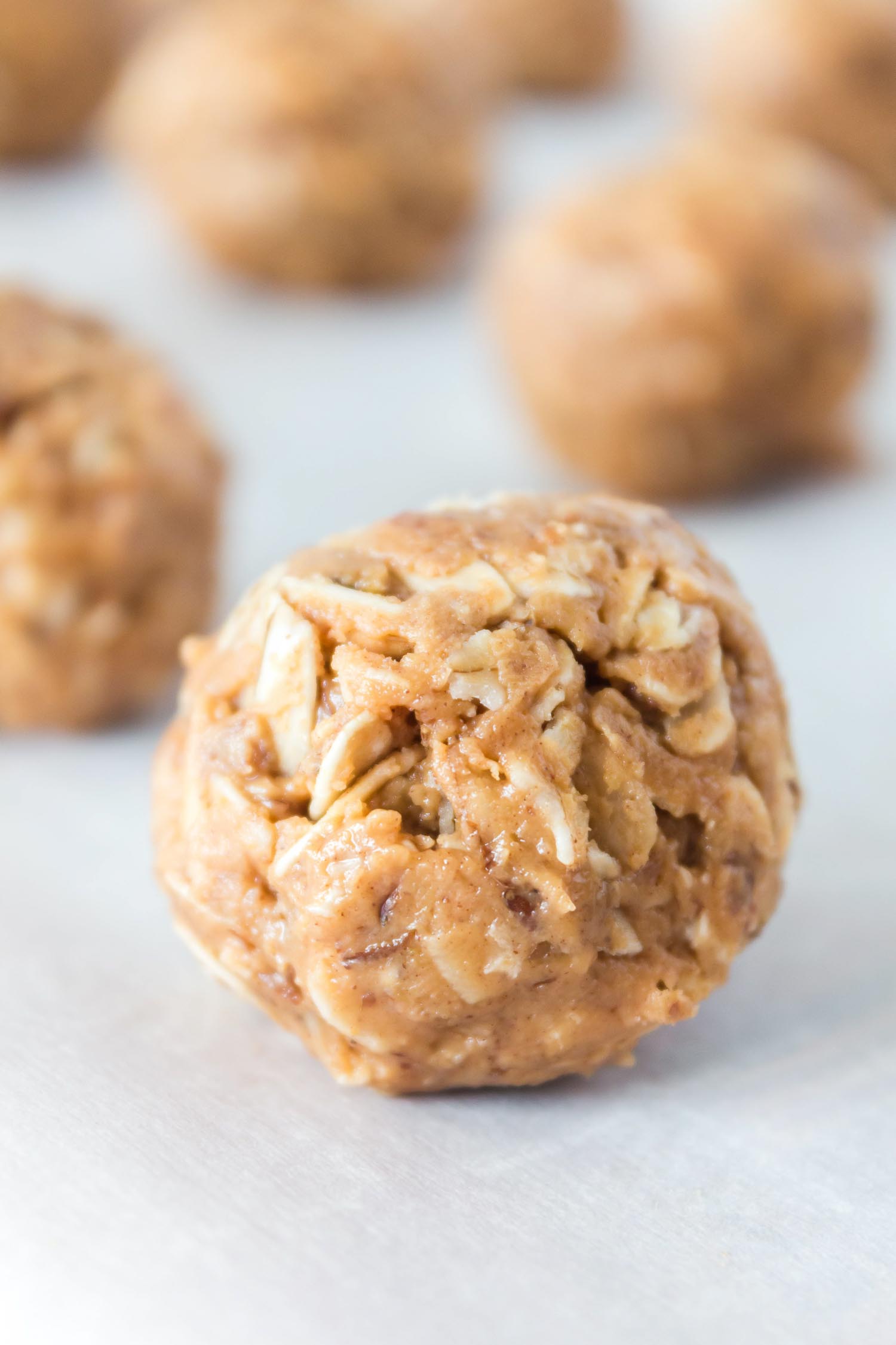 A protein ball up close on parchment paper with other balls behind it.