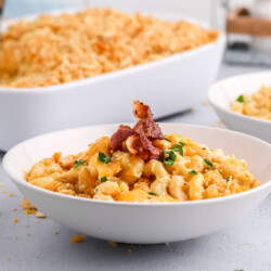 Bowl of creamy back mac and cheese topped with bacon.
