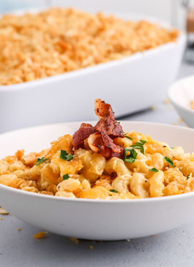 Bowl of creamy back mac and cheese topped with bacon.