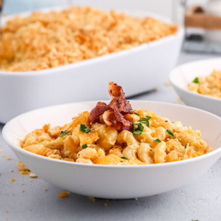 Bowl of creamy back mac and cheese topped with bacon.