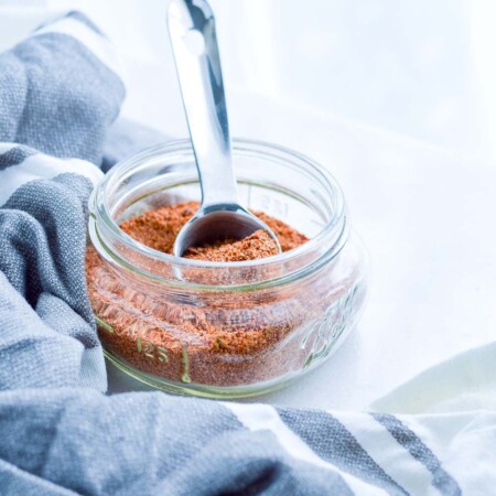 Spoon in a small jar of homemade taco seasoning.