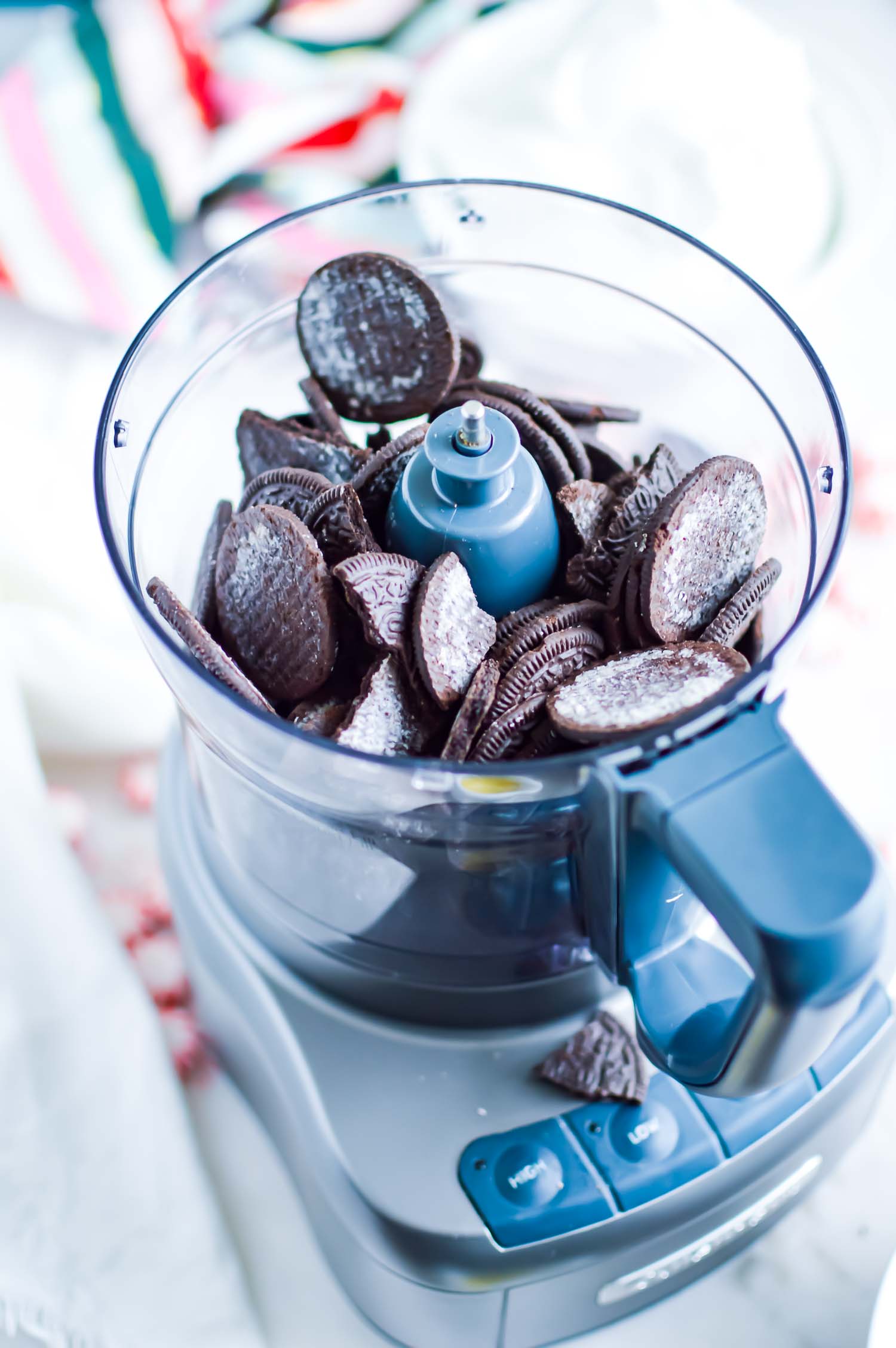 A blue food processor with Oreo cookies in it.