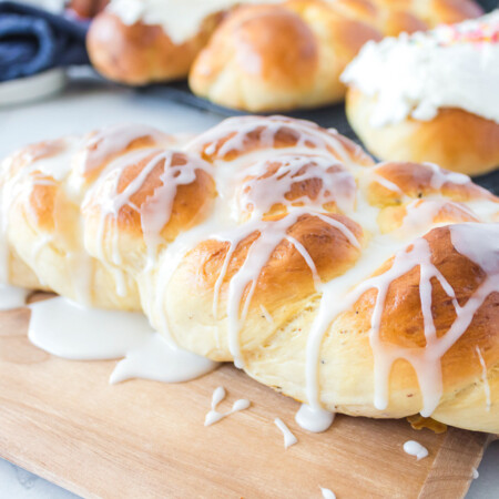 Loaf of glazed Swedish cardamom bread on a wooden board.