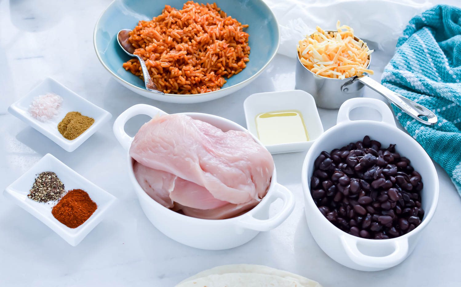 Easy Chicken Burrito recipe ingredients in  separate containers, spices, butter, Spanish rice, cheese, chicken and beans.