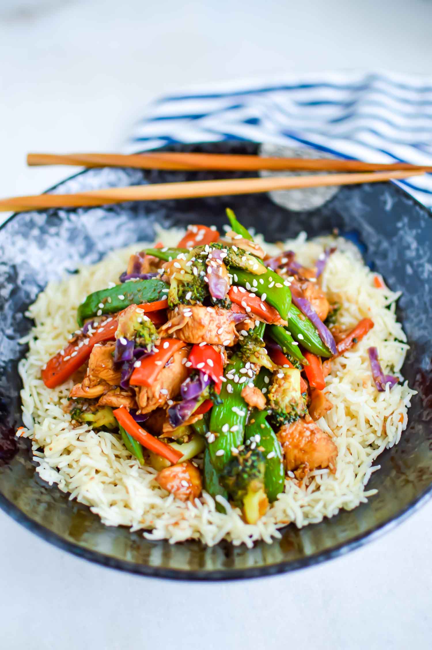 close up picture of chicken stir fry over rice in a bowl