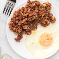 Corned beef hash on a plate with an egg.