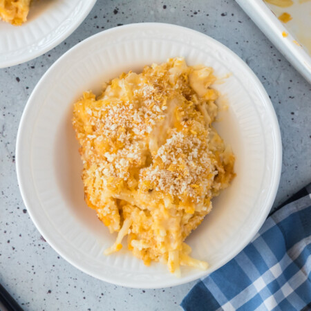 White plate of cheesy potatoes.