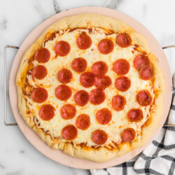 Pepperoni pizza on a wooden board.