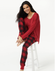 Woman on a stool wearing red and black pajamas.