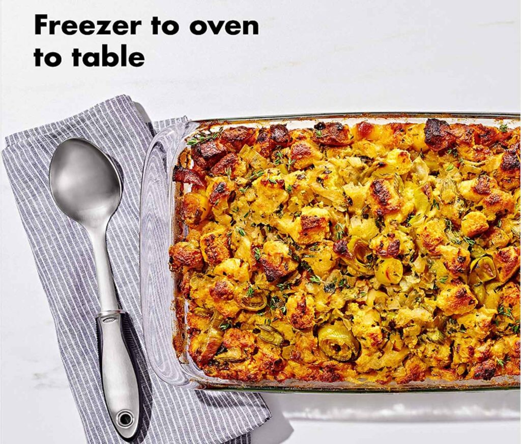 freezer to oven to table words with a glass baking dish with a casserole inside and napkin and spoon.