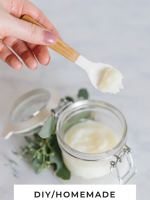 Person using a spoon to scoop homemade Vapor Rub from a small jar.