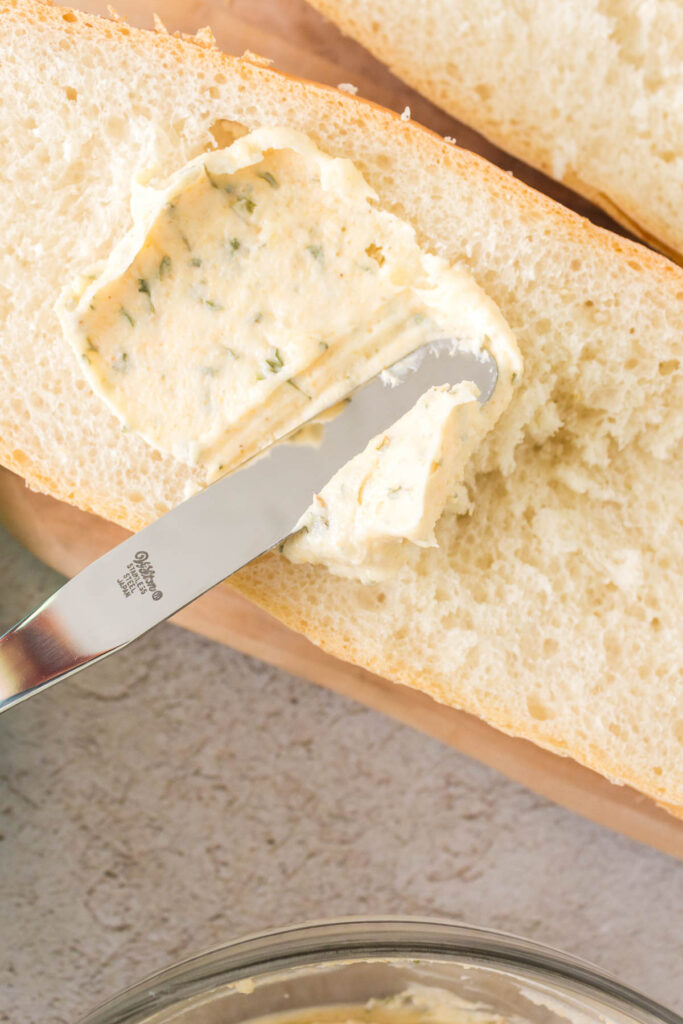 knife spreading butter on a bread slice.