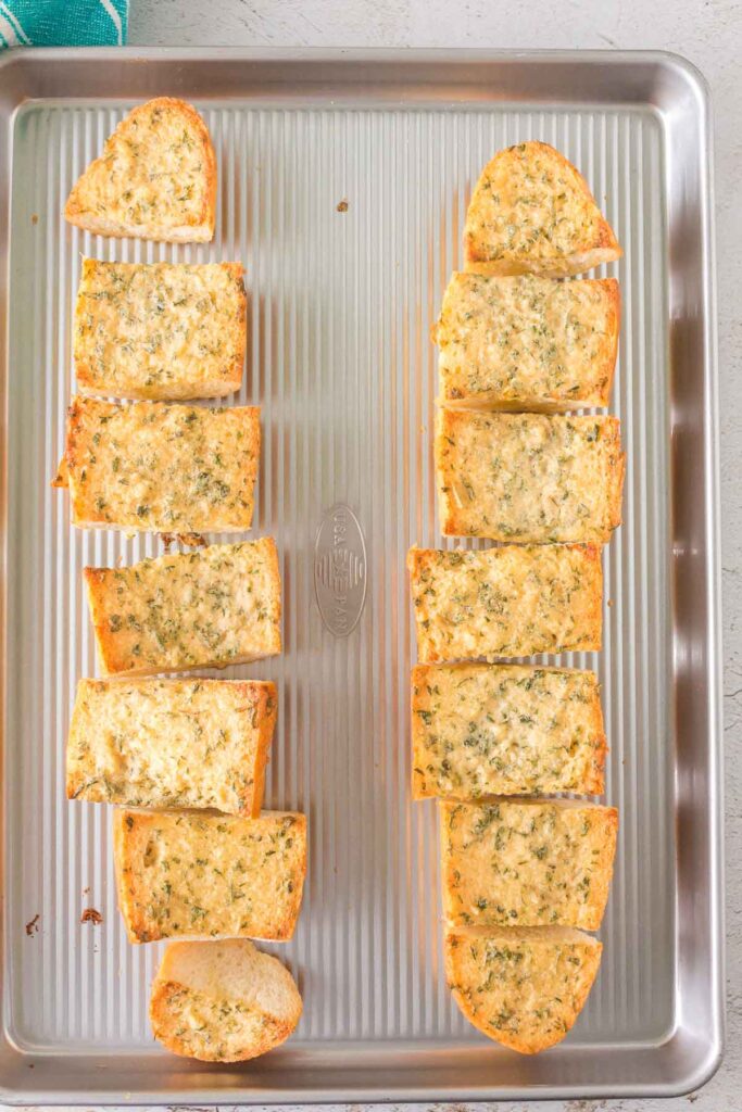 baked garlic bread pieces on a baking tray.