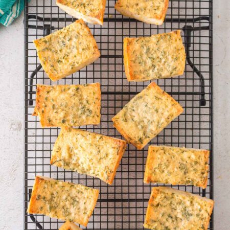 baked garlic bread pieces on a cooling rack.