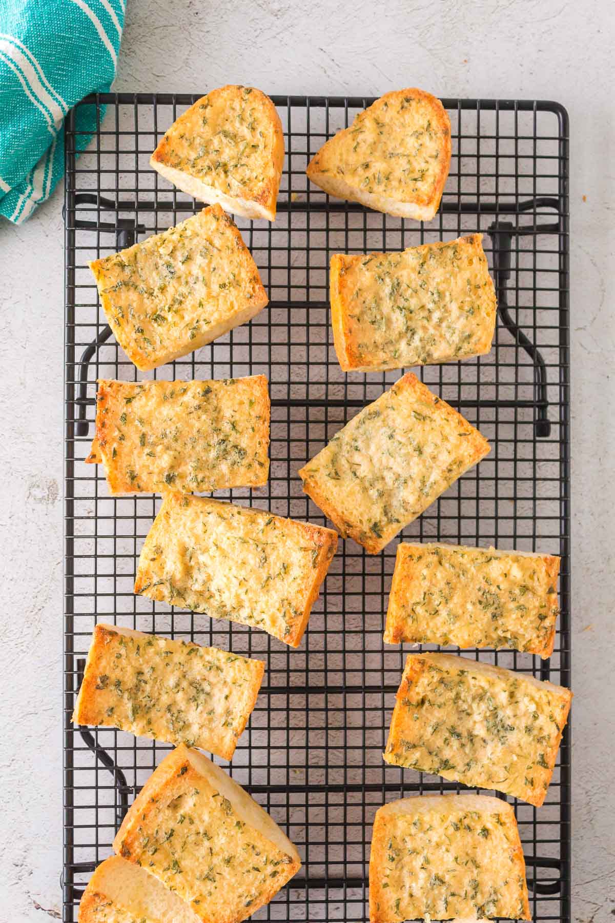 baked garlic bread pieces on a cooling rack.