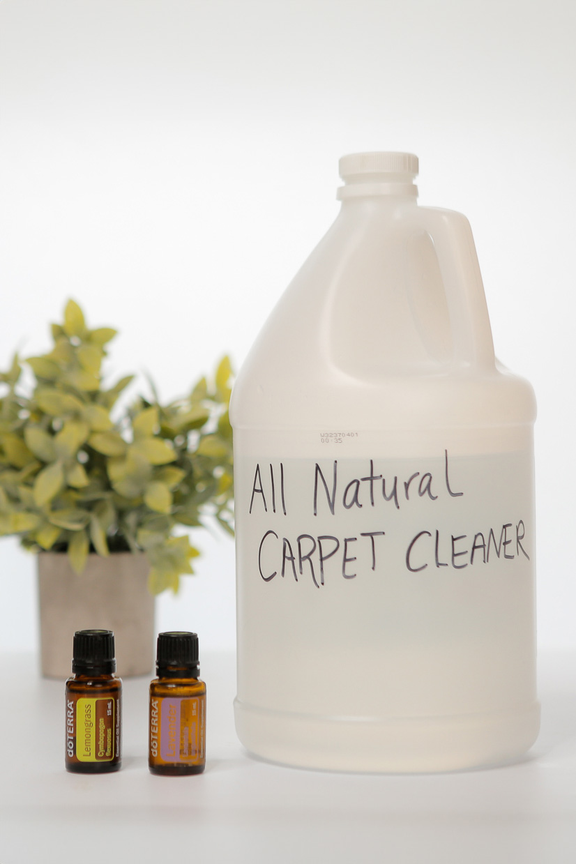 jug of natural carpet cleaner next to essential oils.
