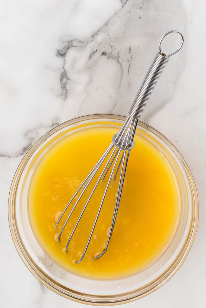 whisk mixing the sauce in a bowl.