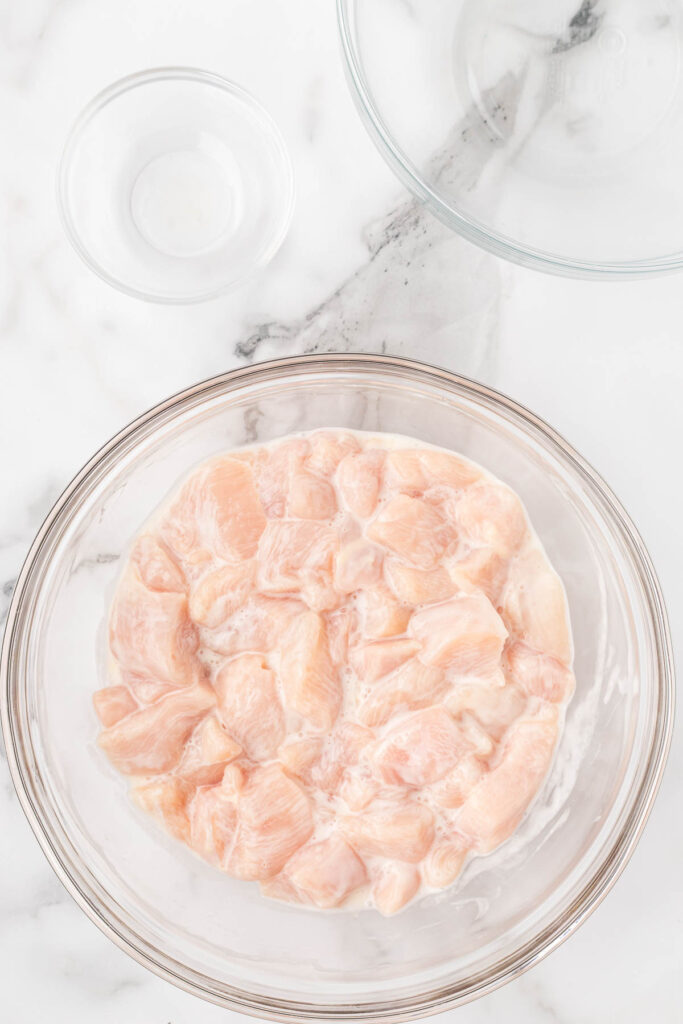 chicken marinating in a bowl.