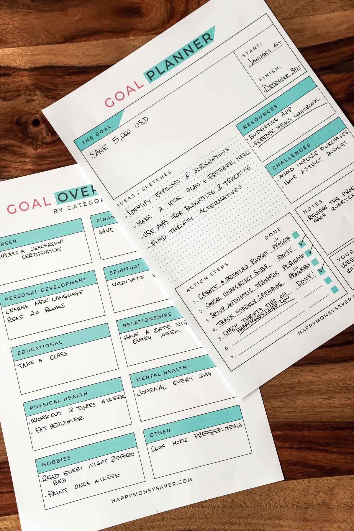 two filled out printed goal planners on a table.